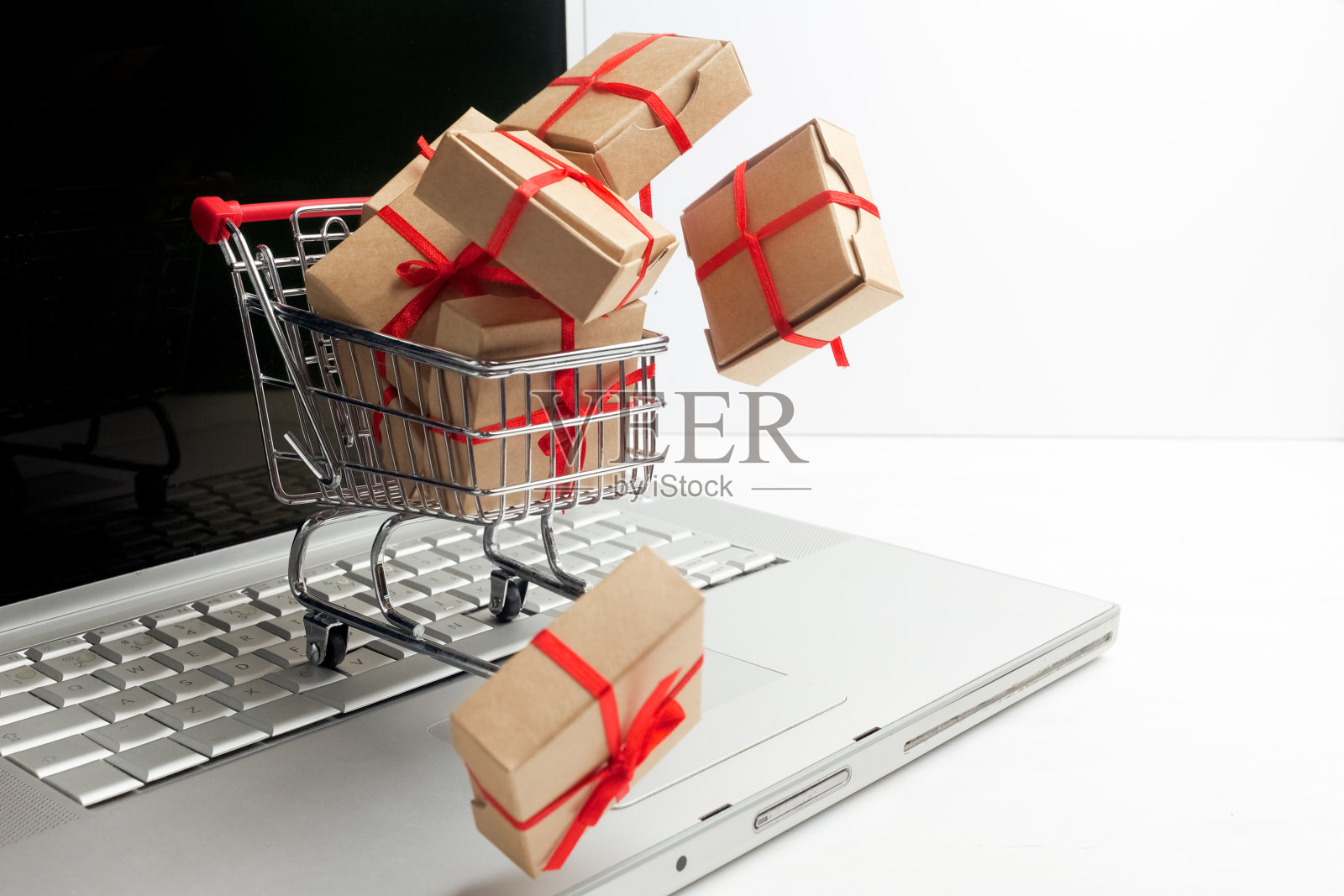 购物车里的纸盒放在笔记本键盘上。关于电子商务的想法,网上购买或销售商品或服务的交易。照片摄影